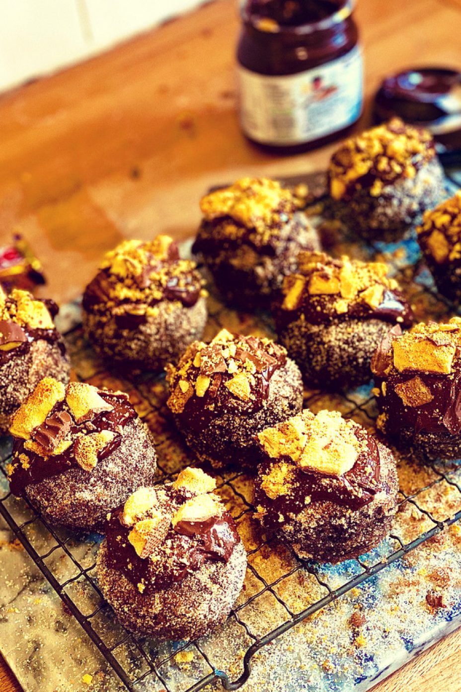 Rows of chocolate nutella muffins on a wire baking rack topped with nutella and crunchies